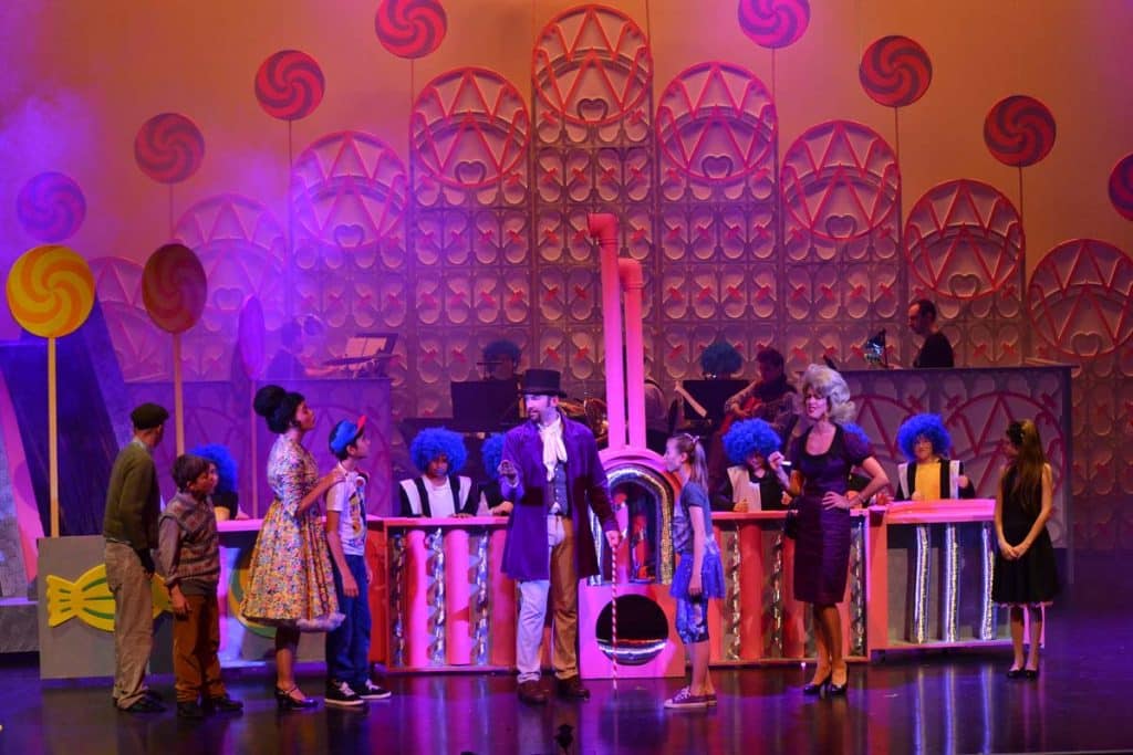 Willie Wonka production in Dubai, UAE. Wonka on stage with kids and parents showing them one of his candy machines.