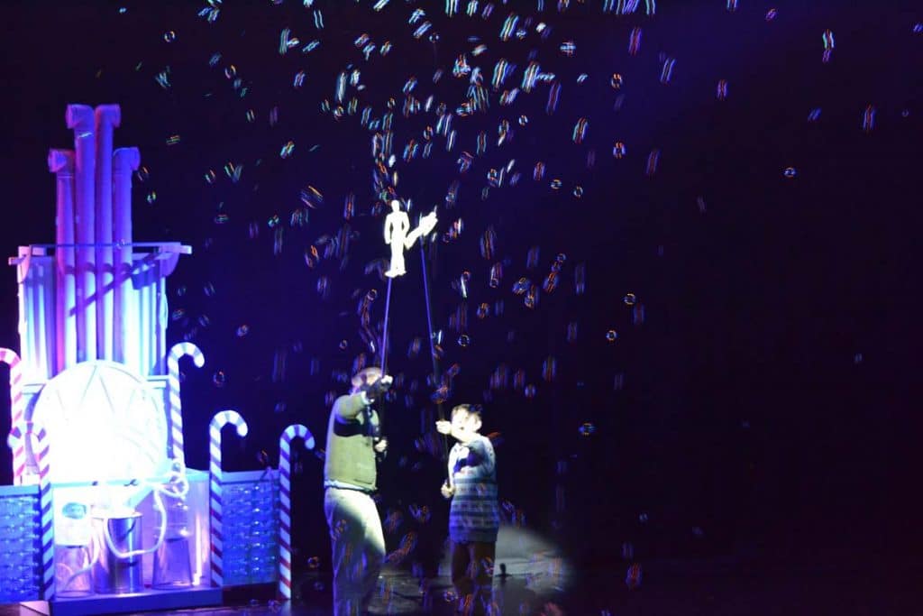 Willie Wonka production in Dubai, UAE. Bubbles float up into the sky with two actors holding smaller versions of themselves to depict the moment where they float up in the film.